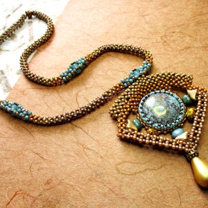 May include: A brown and blue beaded necklace with a large turquoise cabochon pendant and a gold teardrop charm.