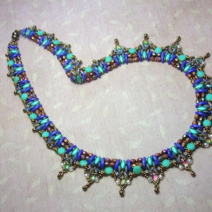 May include: A beaded necklace with a multi-colored design featuring blue, turquoise, copper, and gold beads. The necklace has a decorative fringe with dangling beads.
