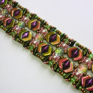 May include: A multi-strand bracelet with green, purple, and pink beads. The beads are arranged in a geometric pattern.