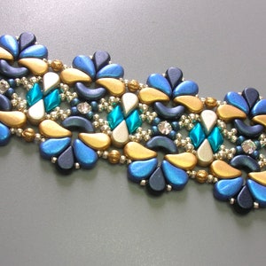 May include: A beaded bracelet featuring a repeating pattern of gold, blue and turquoise beads. The bracelet is crafted with small, round beads and larger, teardrop-shaped beads.