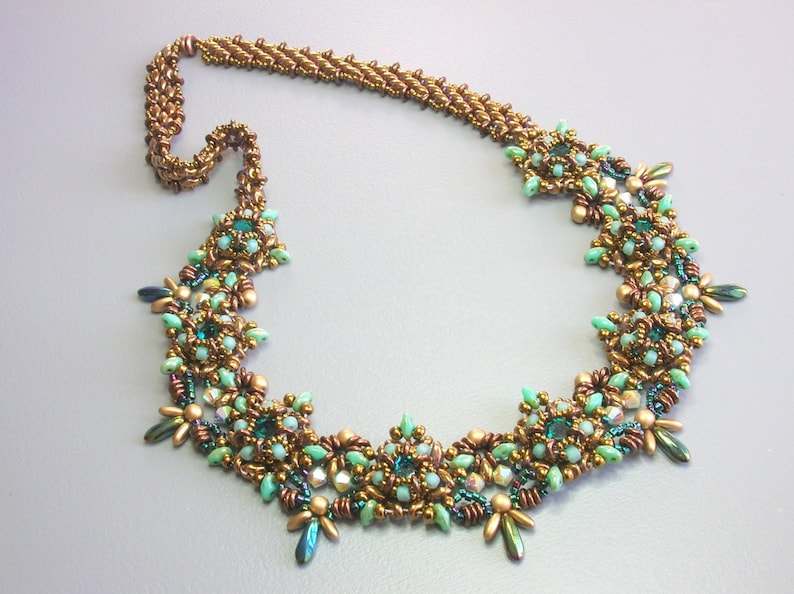 May include: A gold and green beaded necklace with a floral design. The necklace is made with small, round beads and features a variety of green and gold colors.