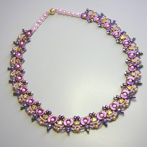 Op de afbeelding: Een delicate ketting gemaakt met paarse, roze en gouden kralen in een bloemmotief.