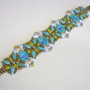 May include: A turquoise, gold, and white beaded bracelet with a magnetic clasp. The bracelet features a repeating pattern of geometric shapes and turquoise stones.