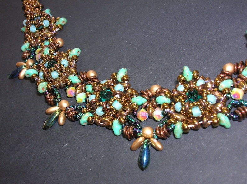 May include: A beaded necklace with a copper and green color scheme. The necklace features a repeating pattern of small, round beads and larger, faceted beads.