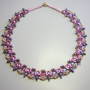Op de afbeelding: Een delicate kralenketting met een bloemenmotief. De ketting is gemaakt van roze, paarse en gouden kralen.