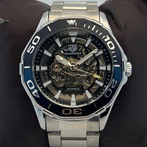 Relógio de pulso masculino vintage TAG HEUER Kenneth Cole automático com mostrador cinza e bisel giratório.