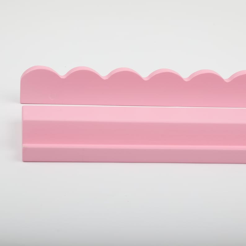 Puede incluir: Juego de estantes de madera rosa de dos piezas. La pieza superior tiene un borde festoneado, mientras que la pieza inferior es un estante rectangular simple. Los estantes est&aacute;n pintados en un suave color rosa pastel, ideal para una guarder&iacute;a.