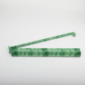 May include: A green, marble-patterned plastic ruler with a hinged design. The ruler is open, showing two connected sections. The color is a marbled green, with a light background.