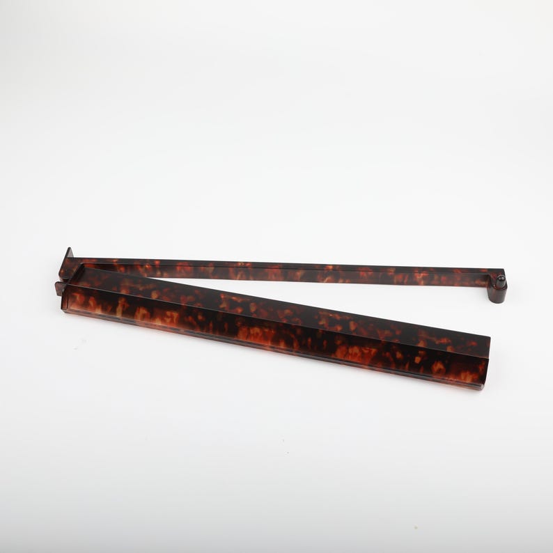 May include: A tortoise shell patterned serving tray with a hinged design. The tray is brown with dark brown and amber accents. The tray is open and angled, showing the interior of the tray. The tray is on a white background.