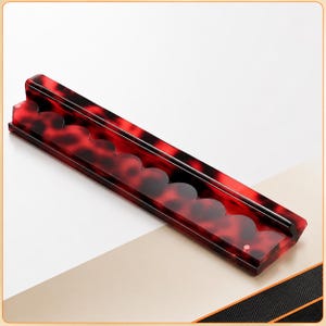Puede incluir: Bandeja rectangular con un patr&oacute;n de carey rojo y negro y un borde festoneado. La bandeja tiene un acabado brillante y bordes elevados. La bandeja est&aacute; en &aacute;ngulo sobre un fondo blanco y beige. Ideal para guardar objetos peque&ntilde;os.