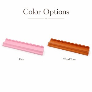 Puede incluir: La imagen muestra dos estantes decorativos de madera. Uno est&aacute; pintado de rosa y el otro tiene un acabado en tono madera. El texto "Color Options" est&aacute; en la parte superior de la imagen, con los nombres de los colores "Pink" y "Wood Tone" debajo.