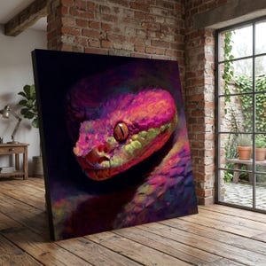 May include: A colourful canvas print depicting a snake's head in close-up. The artwork uses a vivid palette of pink, orange, purple, and green against a dark backdrop. The snake's eye is a striking orange, enhancing the artwork's visual impact.