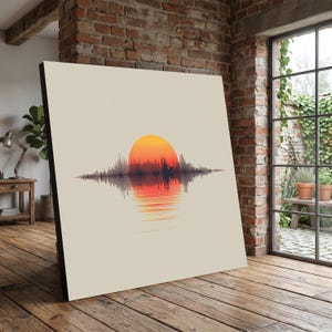 Op de afbeelding: Vierkante canvas print met een zonsondergang ontwerp. Het kunstwerk toont een oranje en gele zon boven een donkere, golfachtige horizon, met een spiegelbeeld eronder. De achtergrond is een neutraal beige.