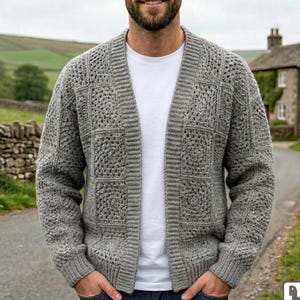 Pode incluir: Um cardigã cinza aberto na frente com um padrão de crochê quadrado em todo o corpo e mangas, usado sobre uma camiseta branca lisa. A peça possui gola, punhos e bainha canelados, confeccionada em fio texturizado de tom neutro.