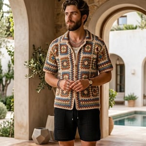 Puede incluir: Una camisa de crochet de manga corta y abierta por delante, con un estampado geométrico en tonos marrones, azules y beige. La camisa se combina con pantalones cortos negros. El conjunto es adecuado para climas cálidos y ocasiones informales.