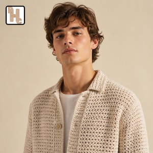 May include: A beige long-sleeved button-down shirt featuring a textured, open-knit crochet pattern. The garment has a classic collar, a front button placket with visible buttons, and is worn over a plain white undershirt against a neutral background.