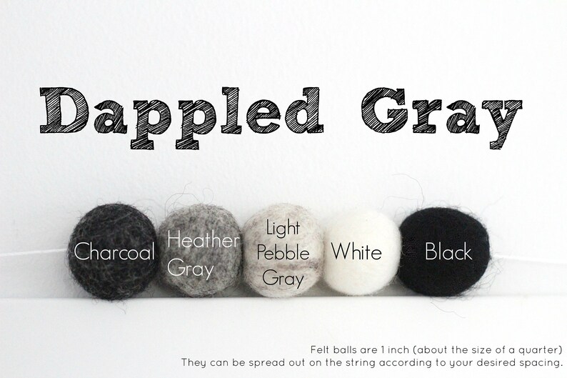 Peut inclure: Cinq boules de feutre dans diff&eacute;rentes nuances de gris, blanc et noir. Les boules sont &eacute;tiquet&eacute;es "Charcoal", "Heather Gray", "Light Pebble Gray", "White", et "Black". Le texte "Dappled Gray" est en haut de l'image. Les boules de feutre mesurent 2,5 cm (environ la taille d'une pi&egrave;ce de 25 cents).