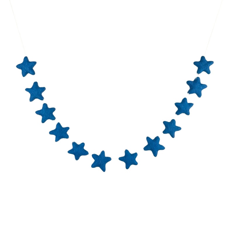 May include: A blue felt star garland with 14 stars hanging on a white string.