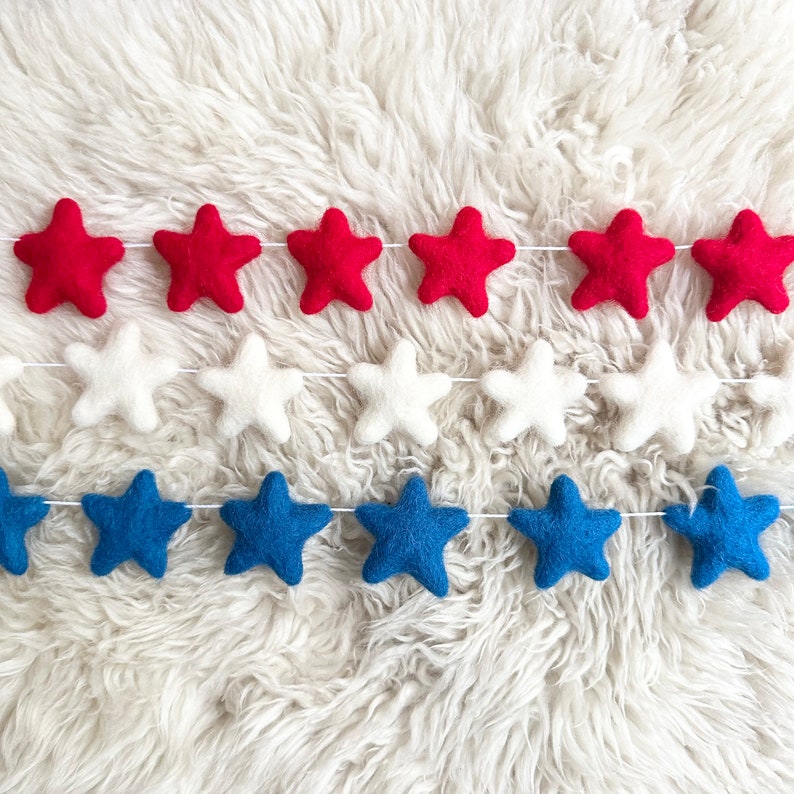 May include: A felt garland with red, white, and blue stars. The garland is perfect for a patriotic celebration.