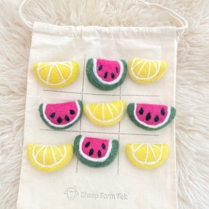 May include: A set of felt watermelon and lemon slices in a white drawstring bag. The bag has the text "Sheep Farm Felt" printed on it.