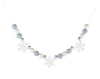 Guirnalda de bolas de fieltro: decoración invernal con copos de nieve en azul, marfil y plata