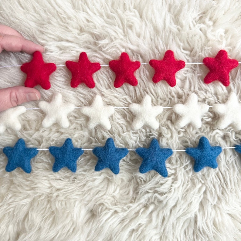 May include: A felt garland with red, white, and blue stars. The garland is perfect for a patriotic celebration.