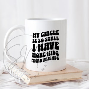 May include: White ceramic mug with a black graphic that reads "My circle is so small I have more kids than friends".