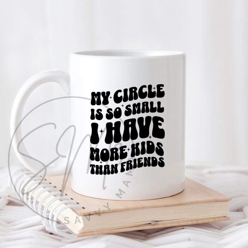May include: White ceramic mug with a black graphic that reads "My circle is so small I have more kids than friends".