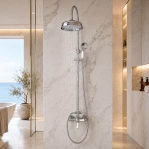 Puede incluir: Un sistema de ducha de cromo pulido que cuenta con un cabezal de ducha redondo grande, un tubo vertical y un accesorio de ducha de mano con mango blanco. La unidad incluye una válvula de control montada en la pared con manijas blancas.