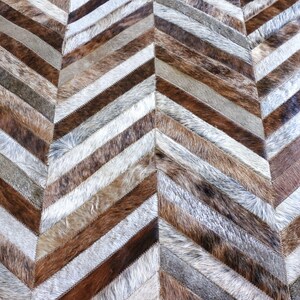 a close-up view of a textured surface with a herringbone pattern, composed of various shades of brown and gray fur.