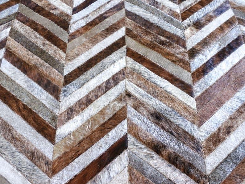 a close-up view of a textured surface with a herringbone pattern, composed of various shades of brown and gray fur.