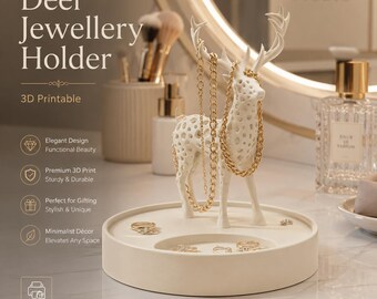Puede incluir: Un soporte para joyas con forma de ciervo blanco, con cuerpo y astas perforadas, sobre una base circular. Las astas sostienen cadenas doradas, mientras que la bandeja muestra varios anillos. El texto en la imagen dice Deer Jewellery Holder.
