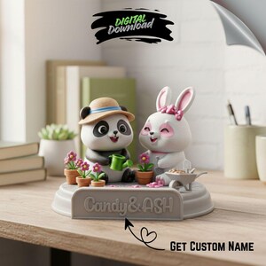 May include: A decorative figurine featuring a panda and a bunny, both smiling. The panda wears a hat and holds a watering can, while the bunny has a pink bow. The base has the text "Candy & ASH" and the words "GET CUSTOM NAME".