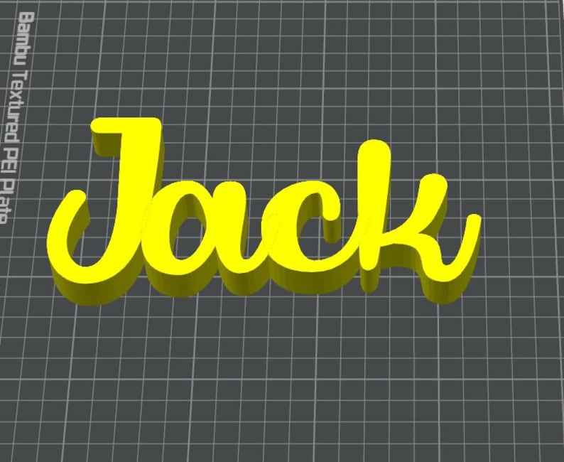 May include: A yellow 3D-printed sign that spells out the name "Jack" in a cursive font. The letters have a slight shadow effect, and the sign is set against a dark gray grid background.