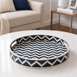 May include: A round serving tray featuring a high-contrast navy blue and white chevron pattern. The tray has a smooth, glossy finish, raised sides, and two integrated cutout handles on opposite sides for easy carrying and handling.