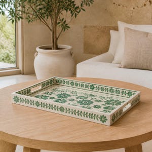 May include: A rectangular serving tray with a white base and a green floral pattern. The design features a repeating vine motif along the edges and a central arrangement of various green flowers. The tray includes two integrated side handles.