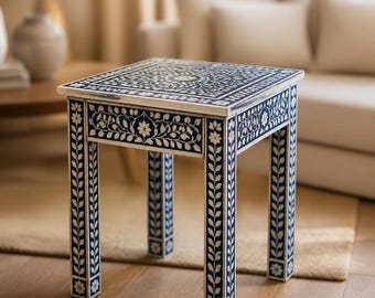 Peut inclure: Une table d'appoint carrée présentant un motif floral incrusté bleu foncé et blanc sur le dessus, le tiroir avant et les quatre pieds droits. Le design complexe se compose de motifs de feuilles et de fleurs répétés sur toutes les surfaces.