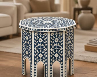 Peut inclure: Une table d'appoint octogonale dotée d'une base bleu profond avec des motifs incrustés de fleurs et de vignes blanches. La table présente un plateau plat et des découpes en arc à la base de chaque panneau, avec un motif botanique détaillé.