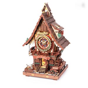May include: A wooden model clock house featuring a central circular clock face, a water wheel, and a banner reading "Fall down the rabbit hole." The structure includes a small fence, stairs, and the text "ROKR" and "WONDERLAND" on the base.