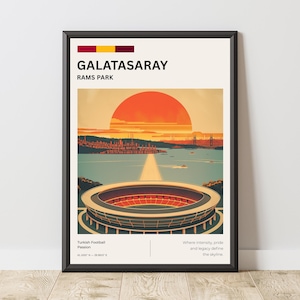 Może przedstawiać: Oprawiony wydruk artystyczny przedstawiający ilustrację stadionu z napisem "GALATASARAY RAMS PARK". Grafika przedstawia stadion z czerwono-pomarańczowym zachodem słońca nad akwenem. Wydruk ma kremowe tło i czarną ramę.