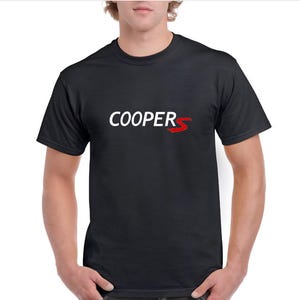 Könnte beinhalten: Schwarzes T-Shirt mit Rundhalsausschnitt und dem Wort "COOPER" in Weiß sowie einem roten "S"-Logo. Das T-Shirt besteht aus weichem Material und ist für den Freizeitgebrauch geeignet.