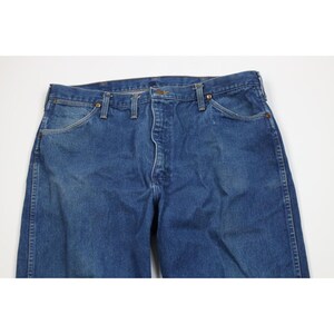 Op de afbeelding: Blauwe jeans van denim met een knoopsluiting, riemlussen en voor- en achterzakken. De jeans heeft een klassieke, rechte pijp en is gemaakt van duurzaam denim materiaal. De jeans heeft een medium blauwe wassing.