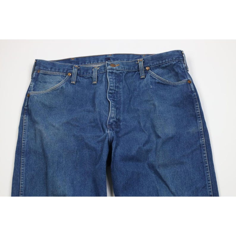 Op de afbeelding: Blauwe jeans van denim met een knoopsluiting, riemlussen en voor- en achterzakken. De jeans heeft een klassieke, rechte pijp en is gemaakt van duurzaam denim materiaal. De jeans heeft een medium blauwe wassing.