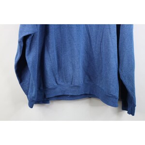 Op de afbeelding: Een effen blauw sweatshirt met lange mouwen en een gem&ecirc;leerde textuur over de gehele stof. Het kledingstuk is voorzien van een geribbelde ronde hals, geribbelde boorden aan het uiteinde van elke mouw en een geribbelde zoom onderaan.
