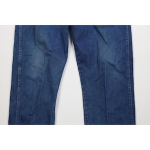 Op de afbeelding: Close-up van een blauwe spijkerbroek. De jeans heeft een klassiek ontwerp met vijf zakken, met een rechte pijp. De denim heeft een medium wassing met wat vervaging en slijtage.