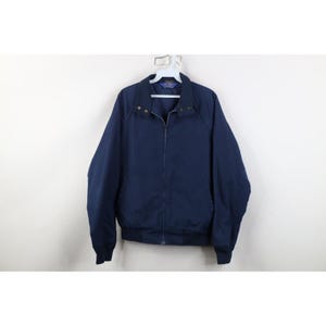 May include: A navy blue jacket with a full zipper closure, a collar, and elastic cuffs. The jacket is hanging on a white hanger. The jacket is a solid color and appears to be made of a lightweight material.