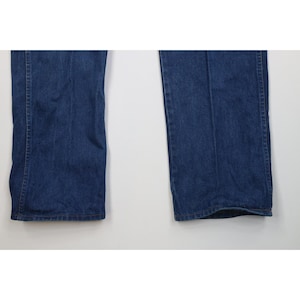 Op de afbeelding: Close-up van twee pijpen van een blauwe denim jeans. De jeans heeft een klassiek ontwerp met vijf zakken en een rechte pijp. De denim heeft een medium wassing, met subtiele vervaging en slijtage.