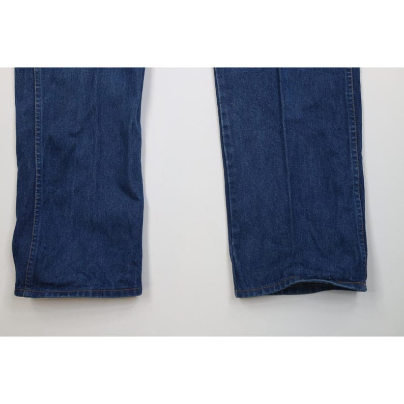 Op de afbeelding: Close-up van twee pijpen van een blauwe denim jeans. De jeans heeft een klassiek ontwerp met vijf zakken en een rechte pijp. De denim heeft een medium wassing, met subtiele vervaging en slijtage.