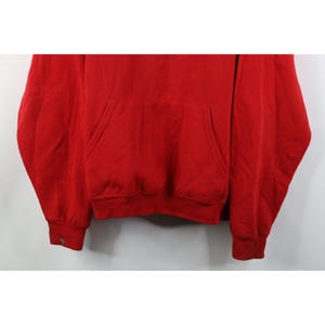 Peut inclure: Un sweat &agrave; capuche rouge uni avec une poche kangourou et des poignets c&ocirc;tel&eacute;s. Le sweat-shirt est fait d'une mati&egrave;re douce et poss&egrave;de une capuche &agrave; cordon. Les poignets ont un d&eacute;tail boutonn&eacute;. Ce haut d&eacute;contract&eacute; convient au quotidien.