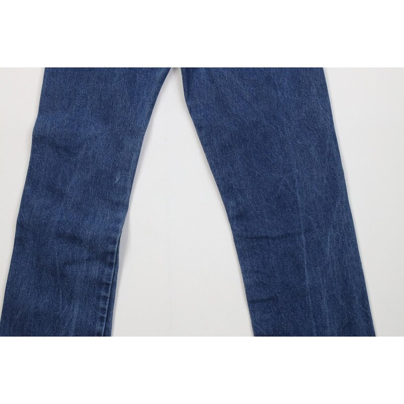Puede incluir: Un par de vaqueros azules. Los vaqueros tienen un dise&ntilde;o cl&aacute;sico de cinco bolsillos y un corte de pierna recta. El denim tiene un lavado medio con sutiles decoloraciones y desgaste.